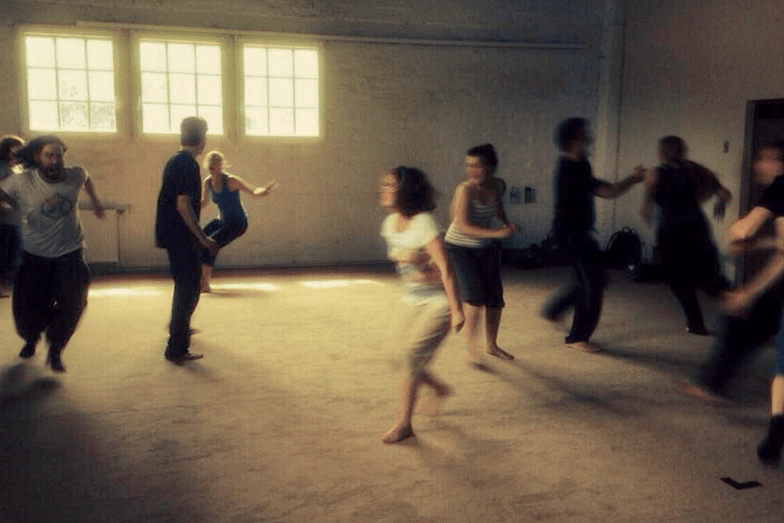 A group of people moving and expressing emotion in a studio
